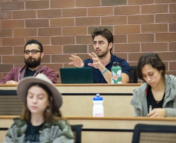 a student talking with a professor during a lecture